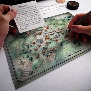 May include: A hand-drawn map of the town of Phandalin, with a compass rose and a scale in feet. The map shows the layout of the town, including buildings, roads, and trees. The text "Phandalin" is written in the upper right corner of the map. A note card with text about the history of Phandalin is visible in the upper left corner of the image.