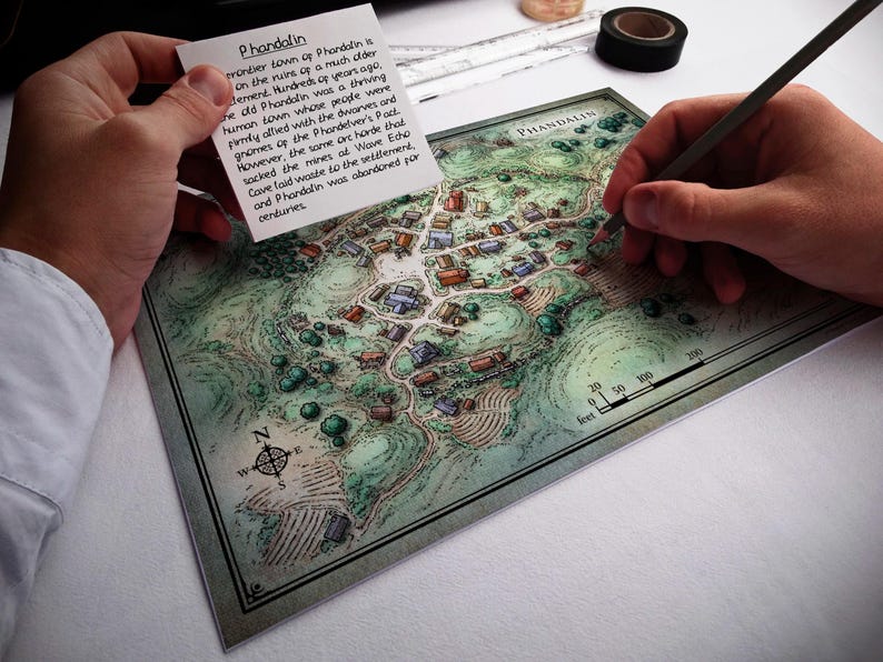 May include: A hand-drawn map of the town of Phandalin, with a compass rose and a scale in feet. The map shows the layout of the town, including buildings, roads, and trees. The text "Phandalin" is written in the upper right corner of the map. A note card with text about the history of Phandalin is visible in the upper left corner of the image.
