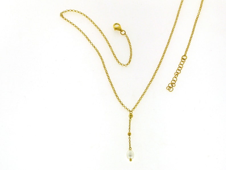 Puede incluir: Un collar de cadena de oro con un colgante de perla &uacute;nico y peque&ntilde;as cuentas doradas.