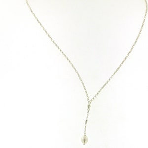 Puede incluir: Un collar de cadena de plata con un colgante de perla.