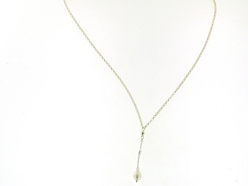 Puede incluir: Un collar de cadena de plata con un colgante de perla.