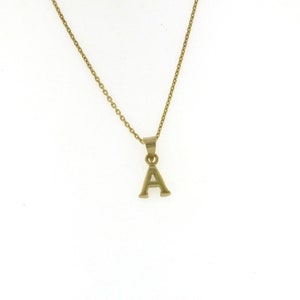 Puede incluir: Un collar de cadena de oro con un pequeño colgante en forma de la letra A.