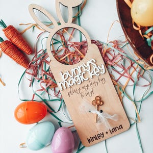 May include: Wooden bunny door hanger with a keyhole and the text "Bunny's Magic Key" and "Please use this key to visit" and "Kinley + Lana".