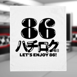 May include: White towel with a black graphic of the number 86 in a bubble font. The text "ハチロク" and "LET'S ENJOY 86!" is below the number. The text "毎日" is in smaller font below the text "LET'S ENJOY 86!"