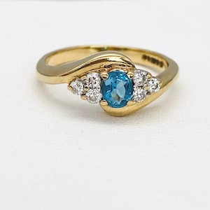 Blue Topaz And  Diamond Ring In 9 Carat Yellow Gold  Size O With Gorgeous Light Blue Central Stone And Diamond Trilogy Shoulders