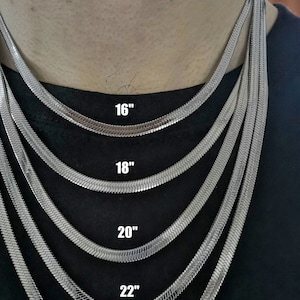 May include: Five silver snake chains of different lengths, 16 inches, 18 inches, 20 inches, 22 inches, and 24 inches, are displayed on a model's neck. The chains are all the same width and style.