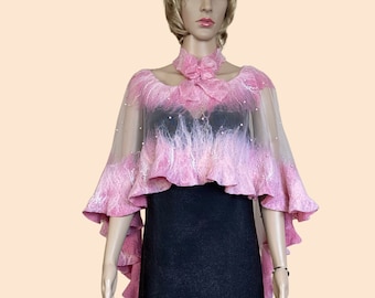 May include: A pink and white sheer shawl with a ruffled edge and beaded accents. The shawl is draped over a mannequin wearing a black dress.