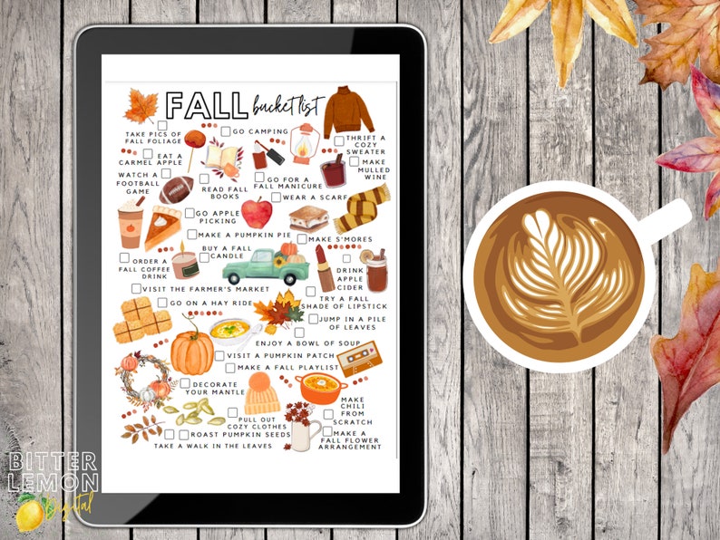 May include: A digital tablet shows a fall bucket list with watercolour illustrations of autumn activities. A cup of coffee with latte art and autumn leaves are on a wooden surface. The list includes activities like apple picking and making pumpkin pie.