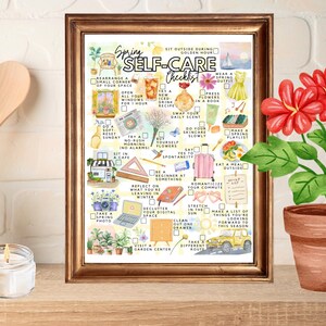 May include: A framed watercolor print titled "Spring Self-Care Checklist" with various illustrated self-care activities. A potted plant with red flowers sits to the right. Wooden utensils and a lit candle are in the background.