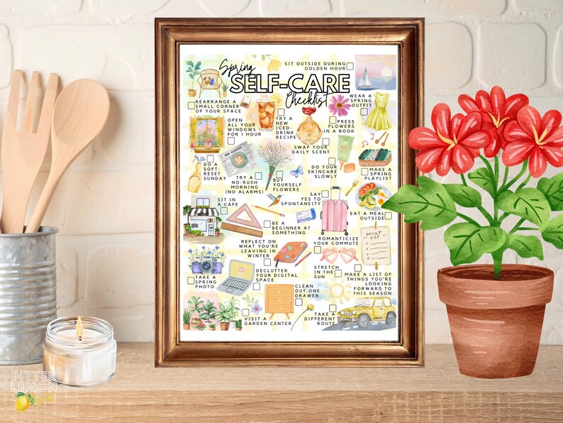 May include: A framed watercolor print titled "Spring Self-Care Checklist" with various illustrated self-care activities. A potted plant with red flowers sits to the right. Wooden utensils and a lit candle are in the background.