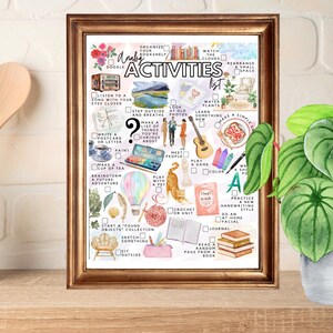 May include: A framed print with a gold-colored frame features a watercolor-style illustration of an "Analog Activities List." The list includes activities like "Listen to a song," "Paint," and "Read a random page from a book." A potted plant sits to the right.