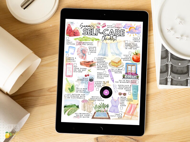 May include: A digital tablet displays a watercolor "Summer Self-Care Checklist." The checklist includes illustrations of watermelon, flowers, and a beach scene. The tablet is on a wooden surface, with a white object and rolled paper nearby.