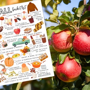 May include: A printed "Fall bucket list" featuring illustrations of autumn activities such as apple picking, making s'mores, and enjoying soup. The list includes various fall-themed items and activities, with a backdrop of red apples on a tree.