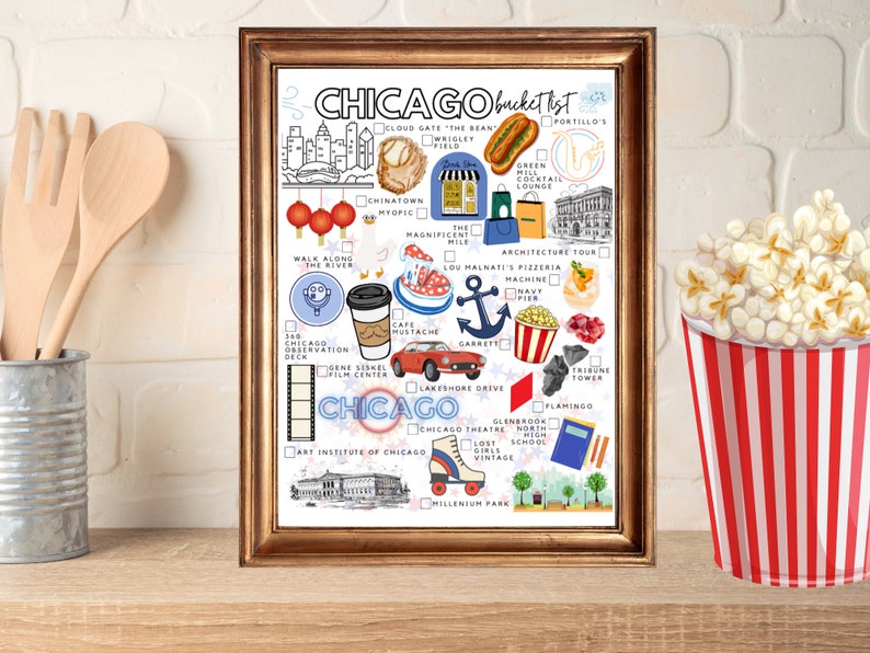 K&ouml;nnte beinhalten: Ein gerahmtes Chicago-Bucket-List-Poster mit farbenfrohen Illustrationen von Sehensw&uuml;rdigkeiten, Speisen und Aktivit&auml;ten. Der Druck enth&auml;lt Kontrollk&auml;stchen neben Symbolen wie einem Hotdog, einem Baseballhandschuh, einem roten Auto und dem Art Institute of Chicago.