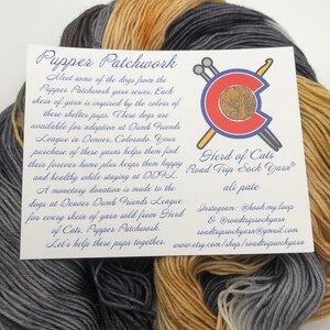 May include: A close-up of a skein of yarn in three colors: gray, tan, and brown. The yarn is labeled "Pupper Patchwork" and "Herd of Cats Road Trip Sock Yarn." The label also includes information about the yarn's purpose and how to purchase it.
