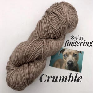 May include: A skein of brown fingering weight yarn labeled "Crumble" and "85/15 fingering".