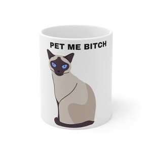 May include: White ceramic mug with a black and white illustration of a Siamese cat and the text "PET ME BITCH" in black.