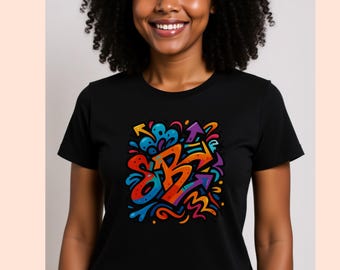 May include: Black t-shirt featuring a colorful graffiti-style design. The graphic includes orange, blue, purple, and yellow arrows and abstract shapes. The design is centered on the front of the shirt.