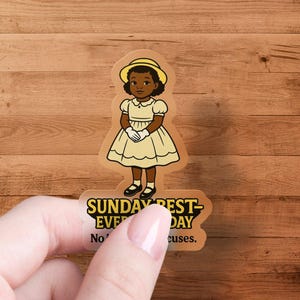 May include: A sticker featuring a cartoon illustration of a young girl wearing a yellow dress and a yellow hat. The text on the sticker reads "Sunday Best - Everyday. No excuses."