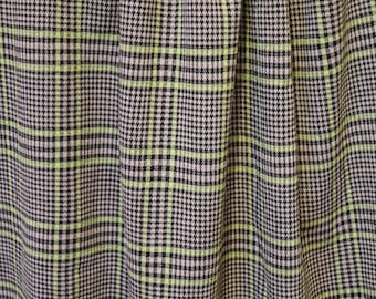 Peut inclure: Gros plan sur un tissu à carreaux noir et vert avec un motif pied-de-poule subtil.