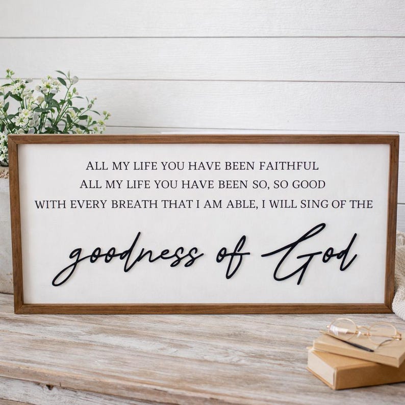 May include: A rectangular wooden sign with a white background and brown frame. The sign features black text that reads "ALL MY LIFE YOU HAVE BEEN FAITHFUL...goodness of God."