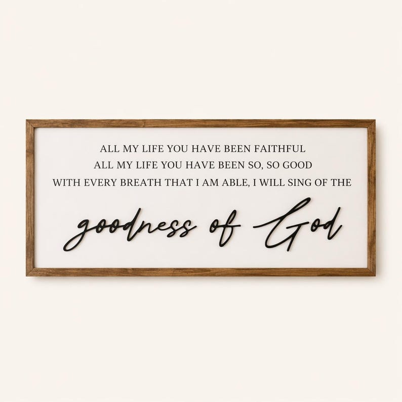 May include: A rectangular wooden framed sign with the words "ALL MY LIFE YOU HAVE BEEN FAITHFUL" and "goodness of God" in black script. The background is white.