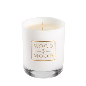 Op de afbeelding: Witte kaars in een glazen pot met een gouden label waarop "MOOD & MOOD" staat.