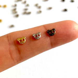 May include: Three small metal bear charms in gold, silver, and bronze.