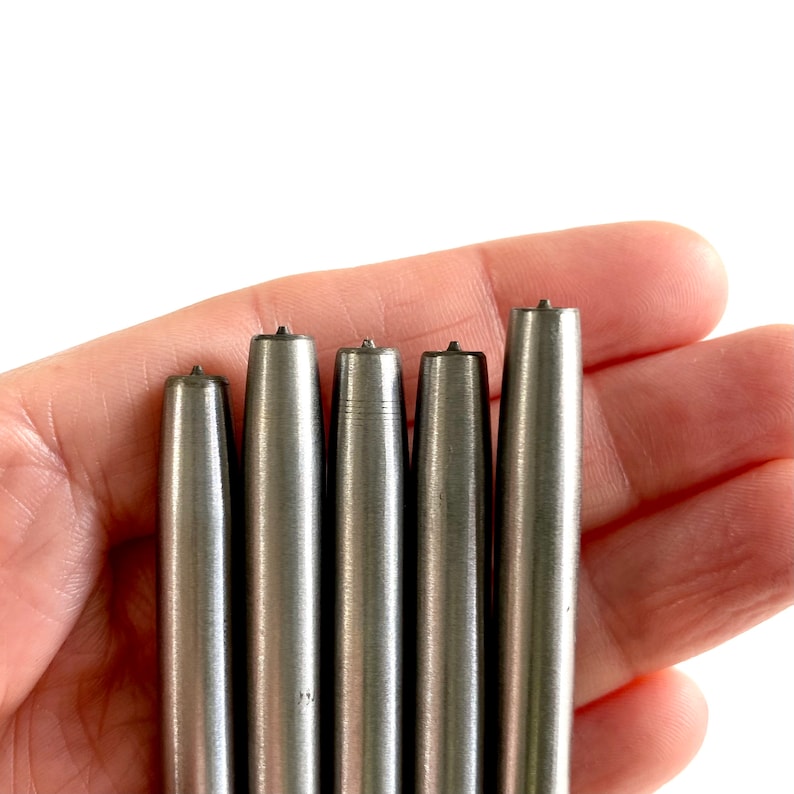 Pu&ograve; includere: Cinque strumenti in metallo argentato con punte appuntite, tenuti in una mano. Gli strumenti sono di diverse lunghezze e sembrano essere utilizzati per l'artigianato o la lavorazione del cuoio.