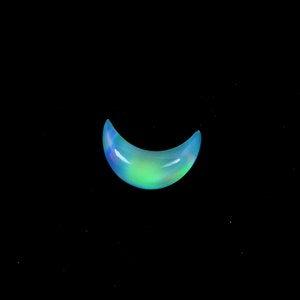 May include: A crescent-shaped opal gemstone with a blue, green, and iridescent sheen.