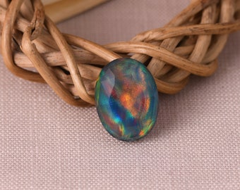 May include: A dark blue oval opal gemstone with iridescent flashes of green, orange, and red.