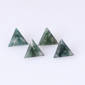 May include: Four green and white triangular agate stones on a white background.