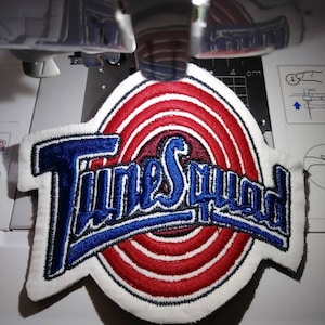 May include: A white, red, and blue embroidered patch with the words "Time Squad" in a blue arch over a red and white target design.