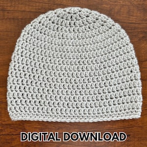 May include: A light gray crocheted beanie hat. The hat is made with a tight stitch pattern, and the texture is visible. The words "DIGITAL DOWNLOAD" are printed in white at the bottom of the image. The hat is sitting on a brown wooden surface.