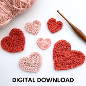 May include: Crocheted heart shapes in shades of red and pink are scattered on a white surface, alongside a ball of pink yarn and a wooden crochet hook. The text "DIGITAL DOWNLOAD" is displayed in black at the bottom of the image.