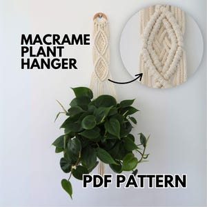 May include: Cream-colored macrame plant hanger with a wooden ring at the top, holding a green leafy plant. The text "MACRAME PLANT HANGER" and "PDF PATTERN" are displayed in black. A close-up shows the macrame knotting.