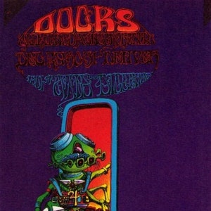 May include: A vintage concert poster for The Doors, featuring a psychedelic illustration of a green creature with large eyes and a red background. The text "The Doors" is in large, stylized letters at the top of the poster. The text "Ann Arbor, Michigan" and "The Great Detour" are also visible.