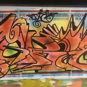 May include: A colorful abstract graffiti art piece on a Priority Mail envelope. The art features a mix of orange, yellow, black, and green colors. The text "PRIORITY MAIL" and "2021" are visible on the envelope.