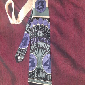 May include: A black and white tie with a blue and green design. The tie features the text "The Mother" and "More Auditor" along with the dates "Fri. 3 June" and "Sat. 4 June".