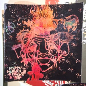 May include: Square artwork with a black background and a vibrant, abstract design in shades of red, orange, and pink. The artwork features a central face-like figure with floral and star-like elements. Text reads "MENTAL HEALTH IS A DRUG."