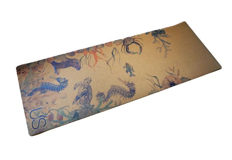 May include: A brown yoga mat featuring a watercolour design of sea creatures, including seahorses, a crab, and a turtle. The mat has the text "USS" printed on the bottom left corner.