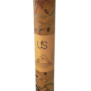 May include: A rolled-up yoga mat with a brown and tan patterned design. The mat is labelled "US" and "Upwards Salute" with the text "Core + Sweat = Grip" and a website address.