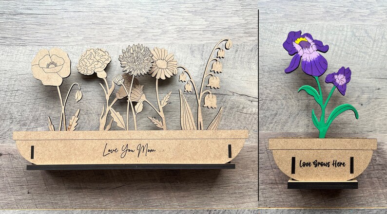 May include: Two wooden flower pot decorations. The first has a variety of flowers and the text "Love You Mom". The second has a purple iris and the text "Love Grows Here".