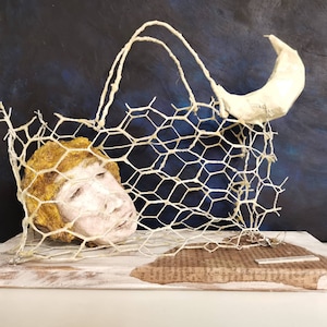An unforgettable night. The Moon, at night, takes the Dreamers away with it. Bag made with metal mesh and the face with modeling clay.