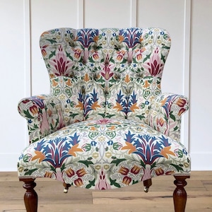 Armchair chair seat in a printed floral leaf William Morrison -style design. Pink red blue green gold cream