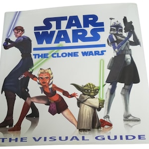 Puede incluir: Portada cuadrada del libro "Star Wars: The Clone Wars - The Visual Guide". La portada presenta ilustraciones de Anakin Skywalker, Ahsoka Tano, Yoda y un soldado clon, con el logo de Star Wars en azul.
