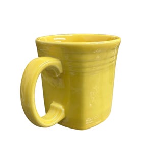May include: A vibrant yellow ceramic mug with a square body and a curved handle. The mug has a glossy finish and a ridged design around the top. The mug is designed for hot or cold drinks.