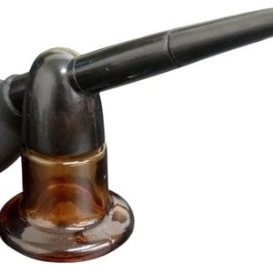 May include: An antique perfume atomizer with a black bulb and curved spout. The atomizer has a brown glass base and a dark brown top. The design is vintage and likely from the early 20th century.