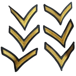 Op de afbeelding: Zes gouden en zwarte chevron-patches. De chevrons zijn geborduurd met gouden draad op een zwarte stoffen achtergrond.