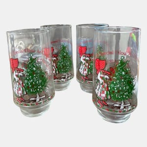 May include: Set of four clear glass tumblers with a Christmas theme. Each glass features a girl in a red bow and dress, a decorated Christmas tree, and the words "Special Glow At Christmas".